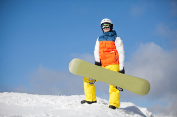female snowboarder against sun and sky